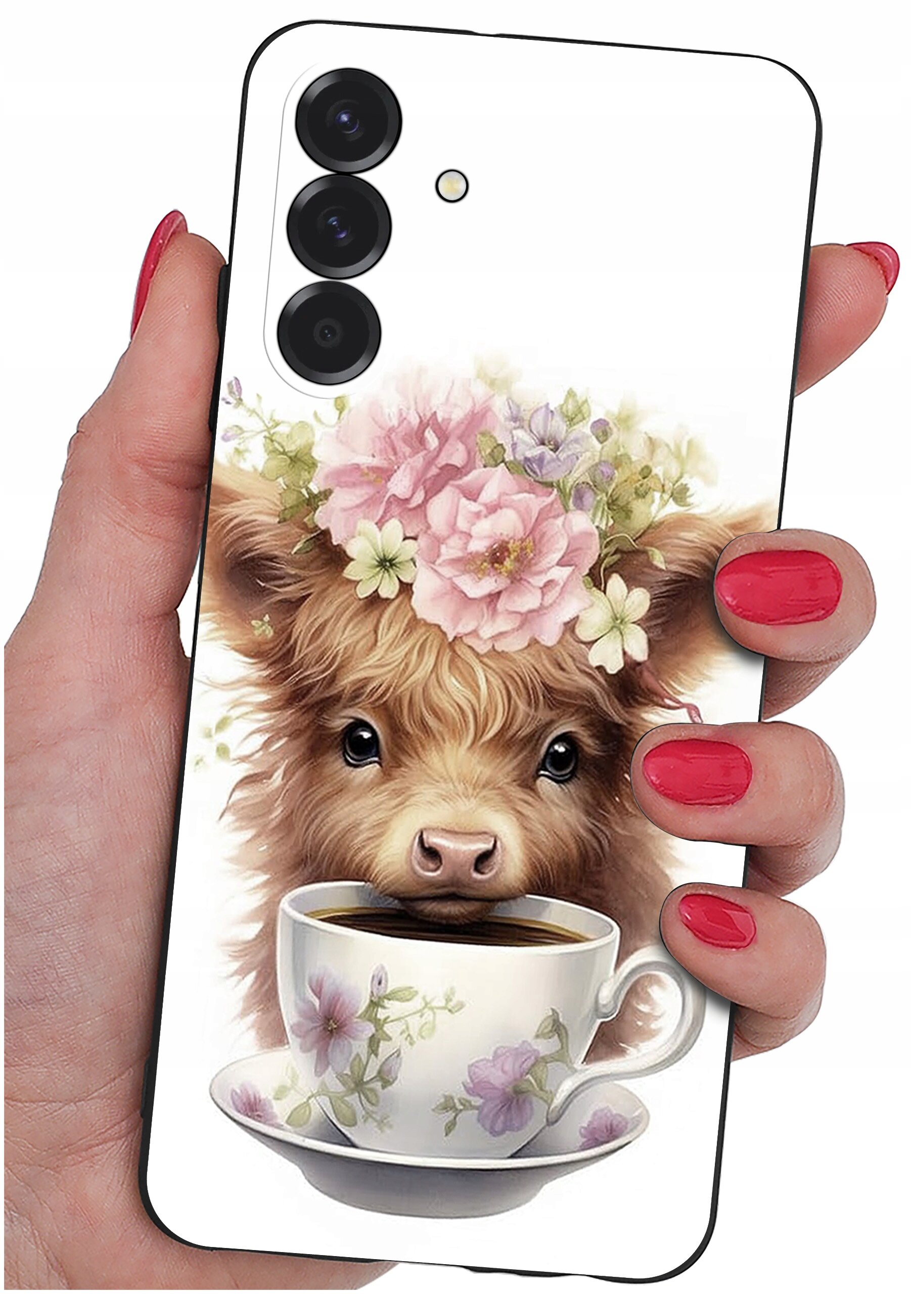 Etui na telefon z nadrukiem przedstawiającym urocze zwierzę z kwiatami na głowie, patrzące znad filiżanki z kawą. Etui trzymane jest w dłoni z pomalowanymi na czerwono paznokciami.