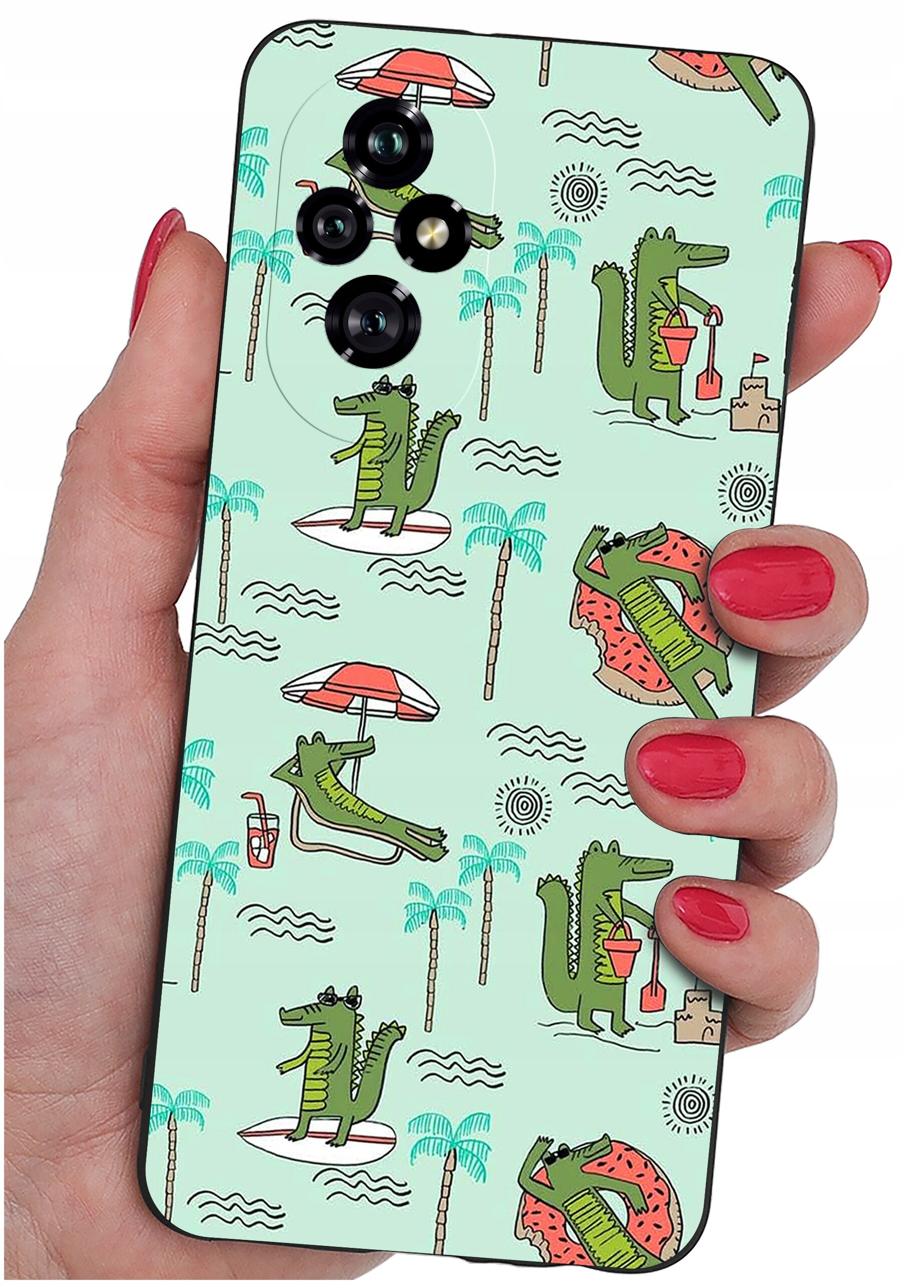 Etui na telefon z motywem zielonych krokodyli na jasnym tle, trzymane w dłoni z pomalowanymi na czerwono paznokciami. Krokodyle są przedstawione w różnych sytuacjach, takich jak leżenie na leżaku czy budowanie zamku z piasku.