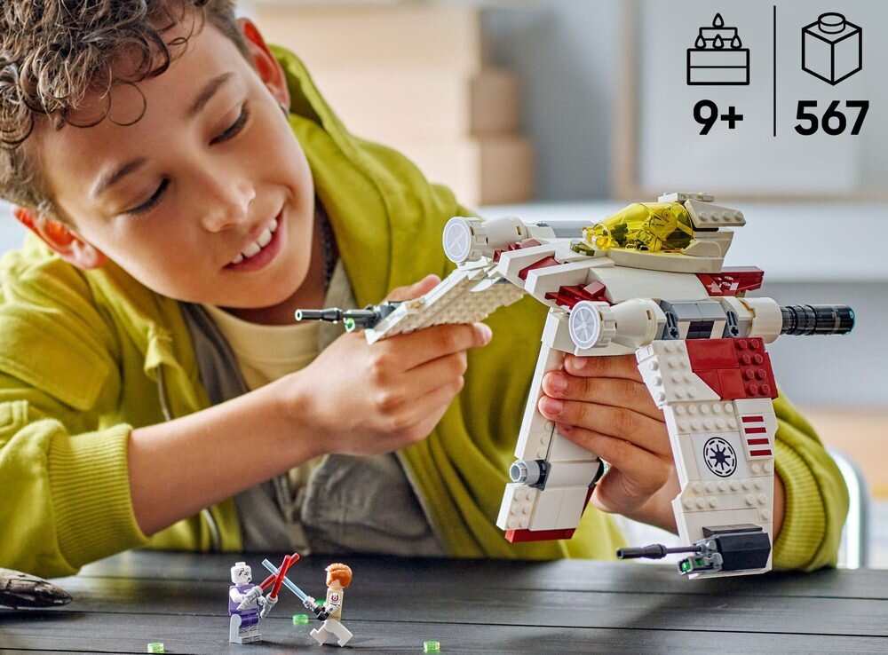 Dziecko bawi się modelem myśliwca z klocków LEGO, a obok znajdują się dwie figurki postaci. W prawym górnym rogu widnieją ikony z oznaczeniem \'9+\' i \'567\'.