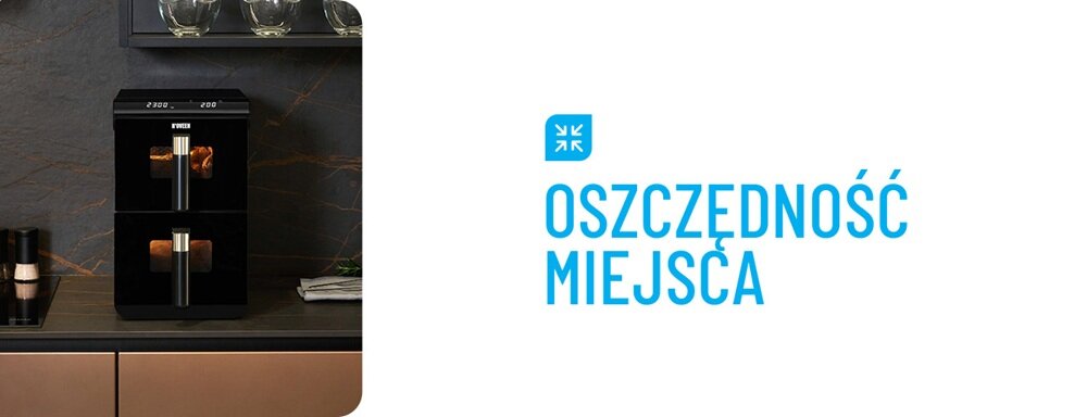 Na obrazie widoczna jest czarna frytkownica z podwójnym koszem, umieszczona na blacie kuchennym. Obok znajduje się napis \'OSZCZĘDNOŚĆ MIEJSCA\' w kolorze niebieskim.