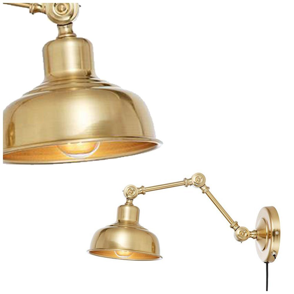Na obrazie widoczny jest złoty kinkiet ścienny z regulowanym ramieniem i okrągłym kloszem. Lampa jest przymocowana do okrągłej podstawy ściennej.