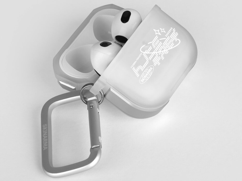 Białe etui na słuchawki z nadrukiem i karabińczykiem z napisem \'SKINARMA\'. Wewnątrz etui znajdują się słuchawki douszne.