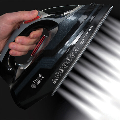Osoba trzyma czarne żelazko, z którego wydobywa się intensywny strumień pary. Na żelazku widoczne jest logo \'Russell Hobbs\' oraz napisy \'POWER STEAM ULTRA\'.