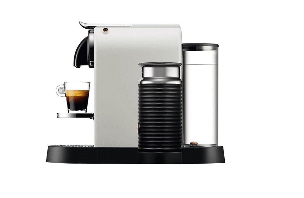 Na obrazie widoczny jest biały ekspres do kawy z filiżanką espresso na podstawce. Obok ekspresu znajduje się przezroczysty pojemnik na wodę oraz czarny pojemnik z metalowym wykończeniem.