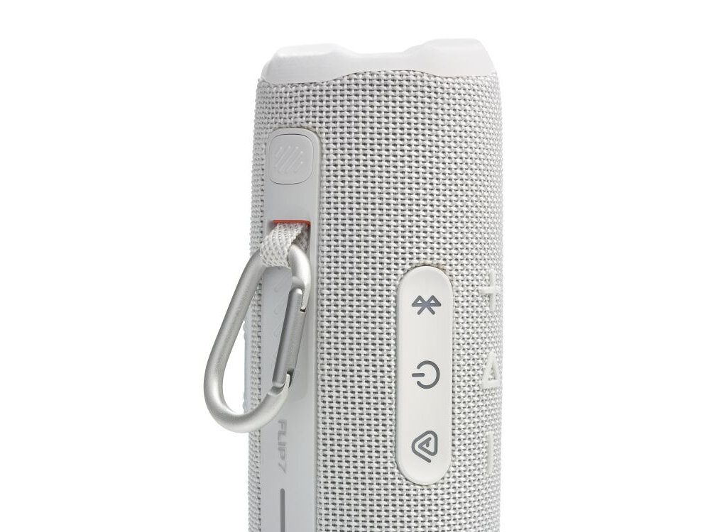 Biały głośnik mobilny z widocznymi przyciskami do sterowania, w tym Bluetooth, zasilanie i odtwarzanie. Na boku znajduje się karabińczyk oraz napis \'FLIP 7\'.