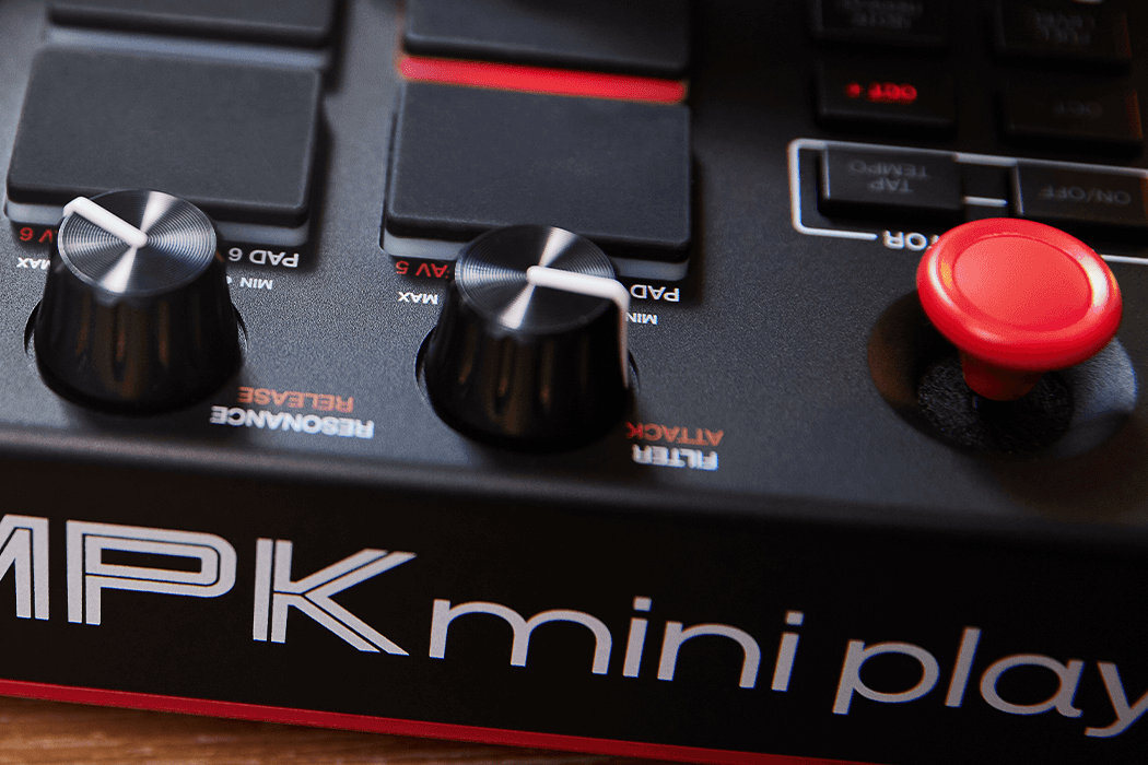 Zbliżenie na panel kontrolny klawiatury z widocznymi pokrętłami i przyciskiem. Na obudowie widoczny jest napis \'MPK mini play\'.