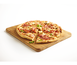 Na drewnianej desce znajduje się pizza z różnymi składnikami, w tym kawałkami mięsa i zieleniną. Jeden kawałek pizzy jest lekko odsunięty od reszty.