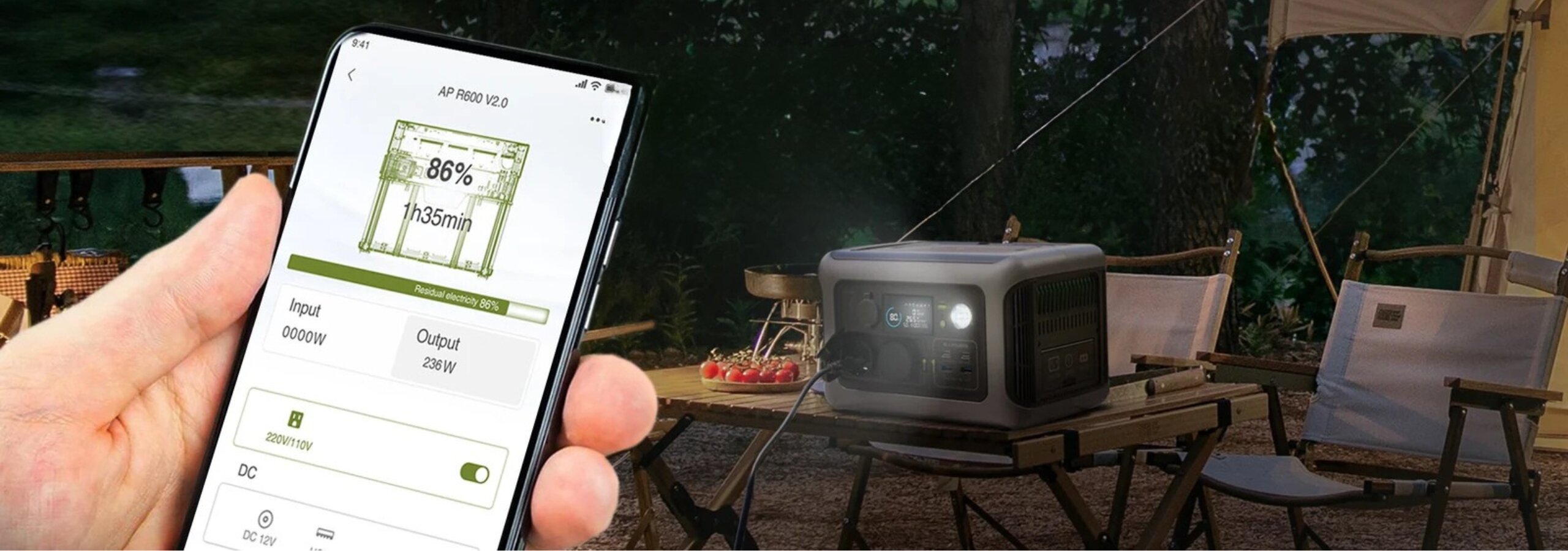 Osoba trzyma smartfon z aplikacją pokazującą stan naładowania 86% i czas 1h35min. W tle widać przenośną stację zasilania ustawioną na stole w otoczeniu krzeseł i roślinności.