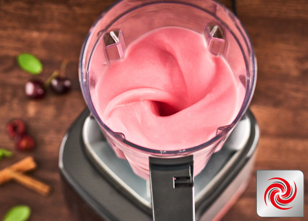 Na obrazie widoczny jest blender kielichowy z różową masą wewnątrz. W prawym dolnym rogu znajduje się logo z czerwonym wirującym symbolem.