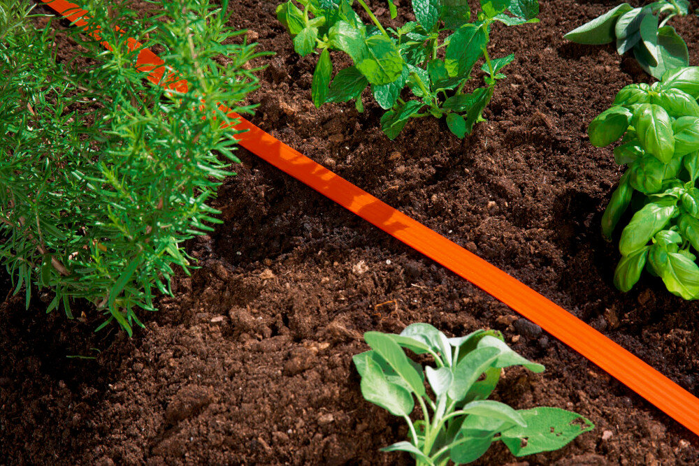 Wąż zraszający GARDENA 7.5 m 00995-20 ogród ziemia rośliny zioła wąż ułożony na ziemi wygodne nawadnianie ogrodu praktyczne rozwiązanie oszczędność wody