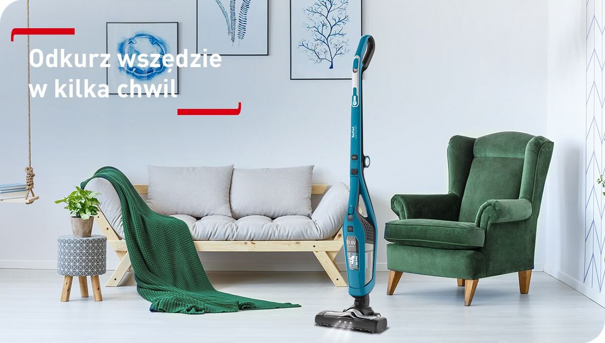 W jasnym salonie z zielonym fotelem i sofą znajduje się niebieski odkurzacz pionowy. Na obrazie widoczny jest tekst: \'Odkurz wszędzie w kilka chwil\'.