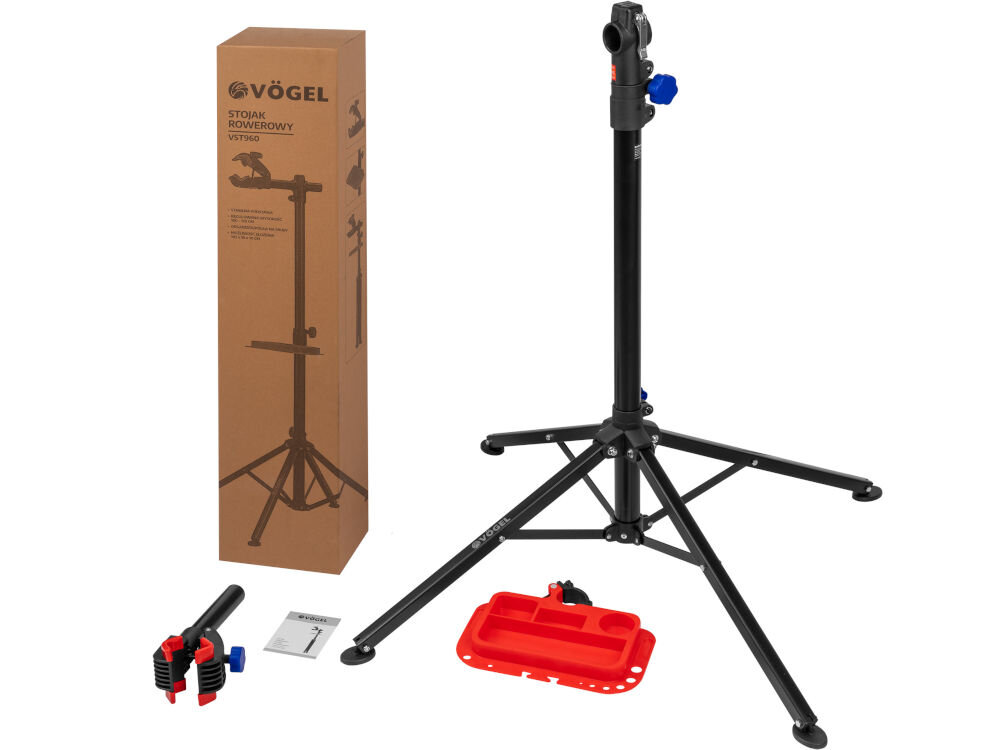 Na obrazie widoczny jest stojak rowerowy z czarnymi, metalowymi nogami oraz kartonowe opakowanie z napisem \'VÖGEL Stojak rowerowy VST-960\'. Obok stojaka znajdują się czerwone akcesoria oraz instrukcja.