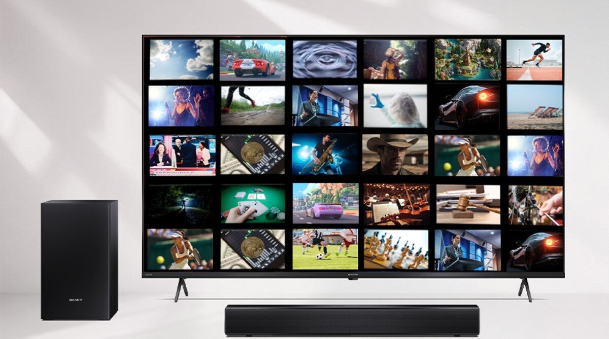 Na obrazie znajduje się telewizor z wyświetlonymi miniaturami różnych scen oraz soundbar i subwoofer. Na subwooferze widoczne jest logo \'SHARP\'.