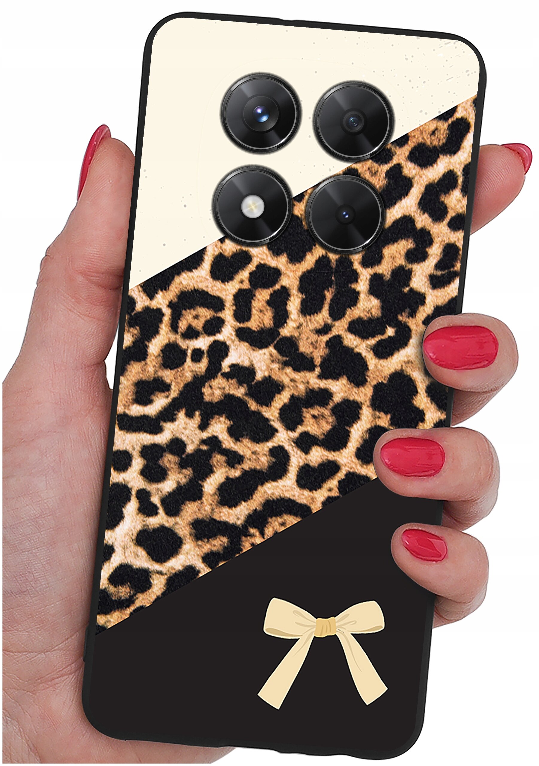 Etui na telefon z wzorem w cętki, posiada trzy okrągłe otwory na aparaty oraz dekoracyjną kokardkę na dole. Trzymane jest w dłoni z pomalowanymi na czerwono paznokciami.