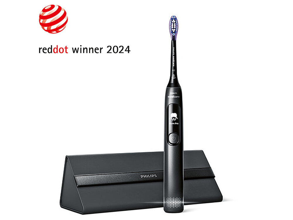 Czarna szczoteczka soniczna z napisem \'Gum Pro\' na uchwycie, stojąca przed czarnym etui z logo \'PHILIPS\'. W lewym górnym rogu widnieje napis \'reddot winner 2024\'.