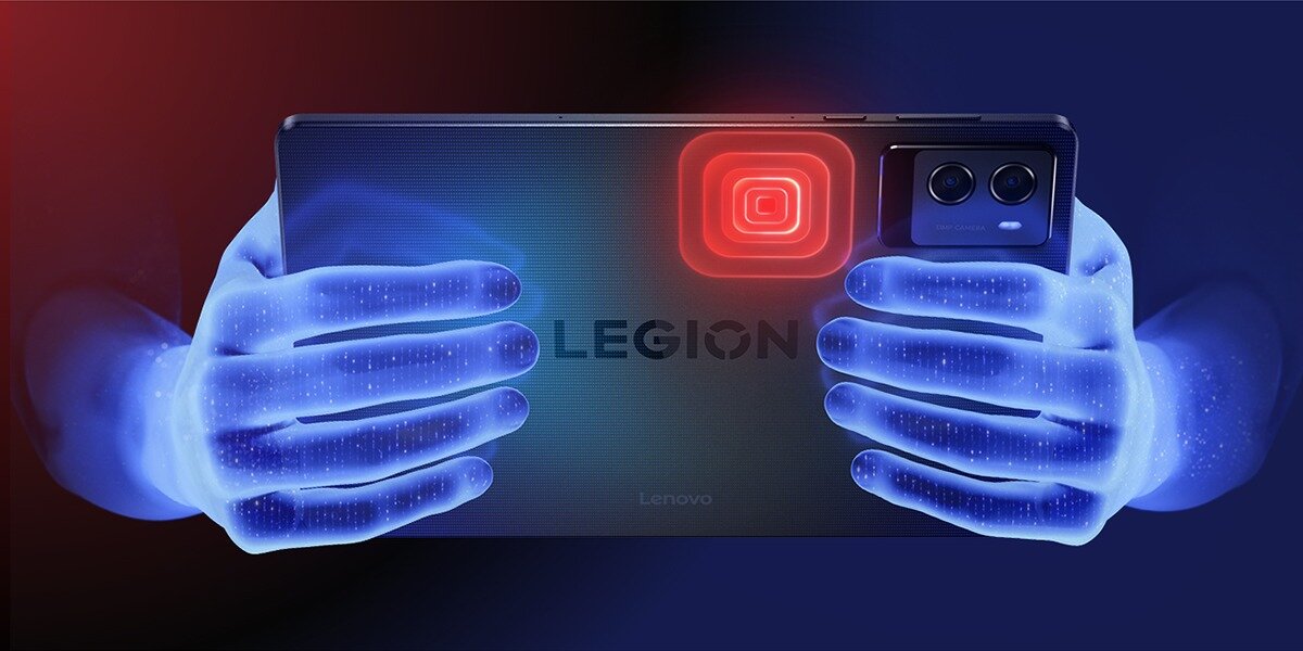 Tablet trzymany w dwóch dłoniach, z widocznym napisem \'LEGION\' na tylnej obudowie. W górnym rogu znajduje się podświetlony na czerwono symbol oraz dwa obiektywy aparatu.