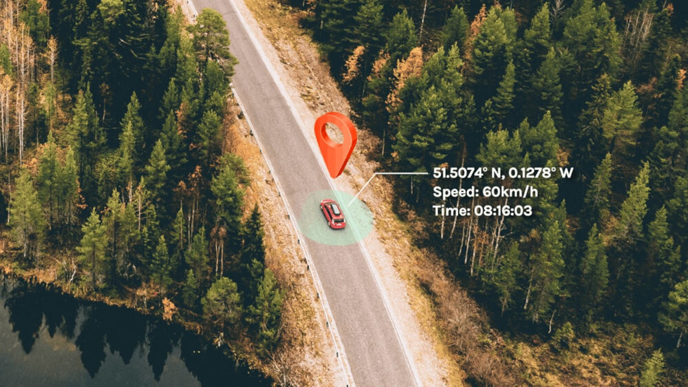 Zdjęcie przedstawia samochód na drodze otoczonej lasem, z nałożonymi danymi: \'51.5074° N, 0.1278° W\', \'Speed: 60Km/h\', \'Time: 08:16:03\'. Nad samochodem widoczna jest czerwona ikona lokalizacji.