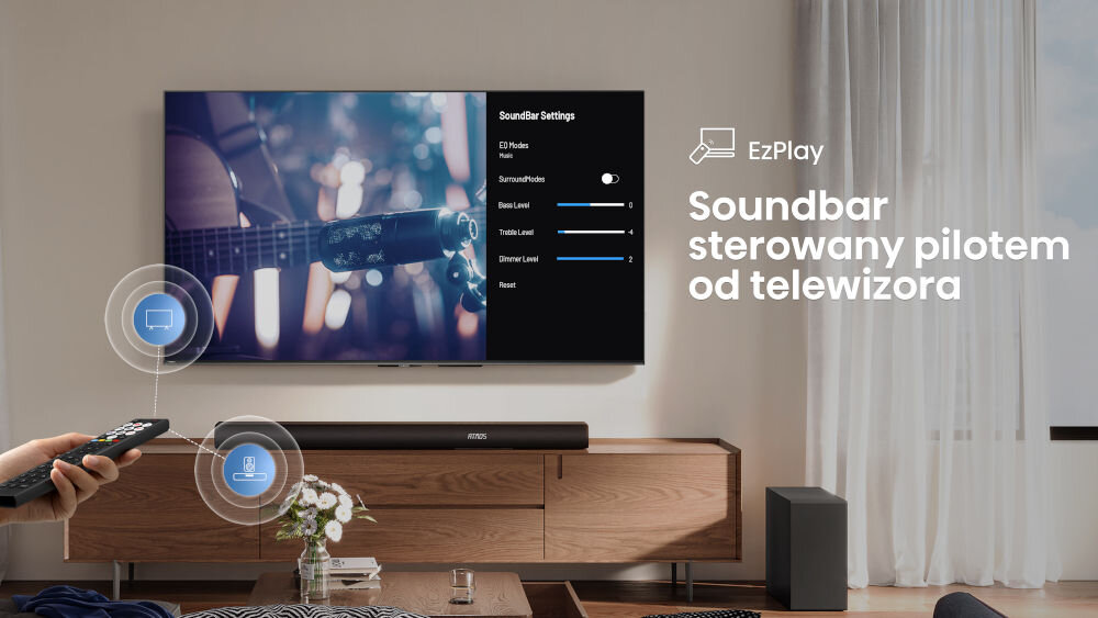 Na obrazie widać telewizor z ustawieniami soundbara oraz napis \'Soundbar sterowany pilotem od telewizora\'. Na szafce pod telewizorem znajduje się soundbar i bezprzewodowy subwoofer.