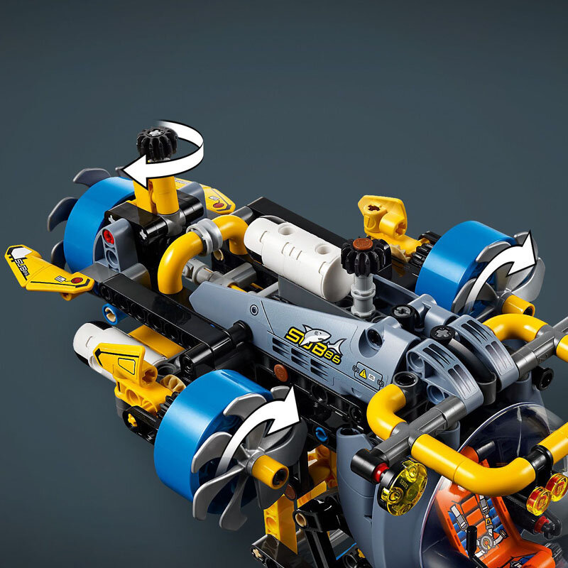 Model LEGO przedstawiający badawczą łódź podwodną z elementami w kolorach żółtym, niebieskim i szarym. Na boku widoczny jest napis \'SUB 36\' oraz grafika rekina.
