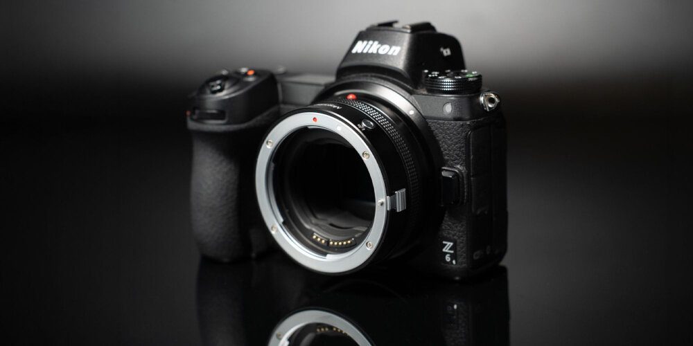ADAPTER BAGNETOWY Z AUTOFOCUSEM MEGADAP EFTZ21 - CANON EF NIKON Z Czarny aparat Nikon z zamocowanym adapterem bagnetowym ustawiony na błyszczącej powierzchni, na ciemnym, rozmytym tle kv lifestyle początek opisu sekcja nagłówkowa