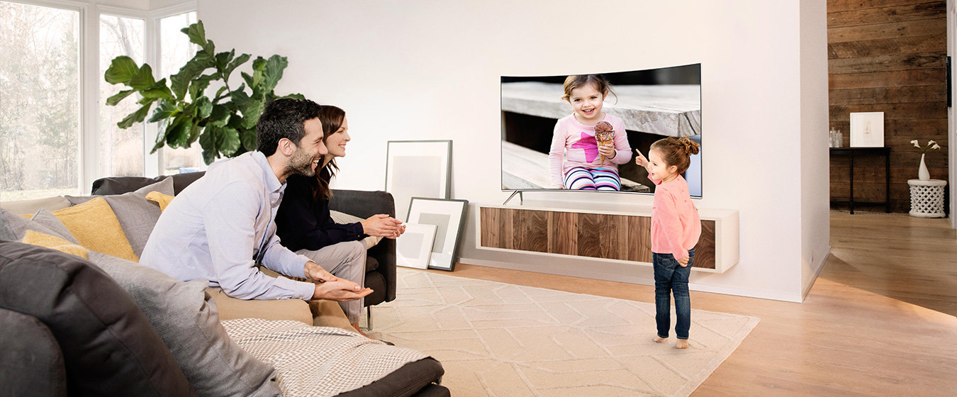 Wzornictwo: Uśmiechnięta rodzina przed SUHD TV w salonie