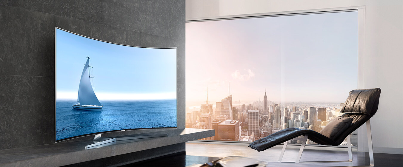 SUHD TV wkomponowane w eleganckie wnętrze salonu z widokiem na panoramę miasta