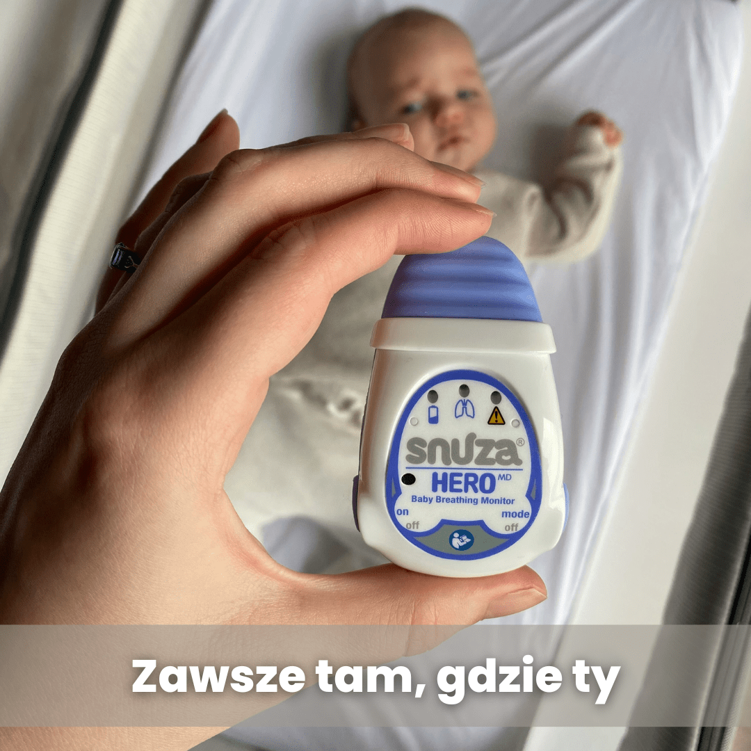 Osoba trzyma urządzenie z napisem \'snuza HERO MD Baby Breathing Monitor\'. W tle widać niemowlę leżące na białym prześcieradle, a na dole obrazu znajduje się tekst \'Zawsze tam, gdzie ty\'.
