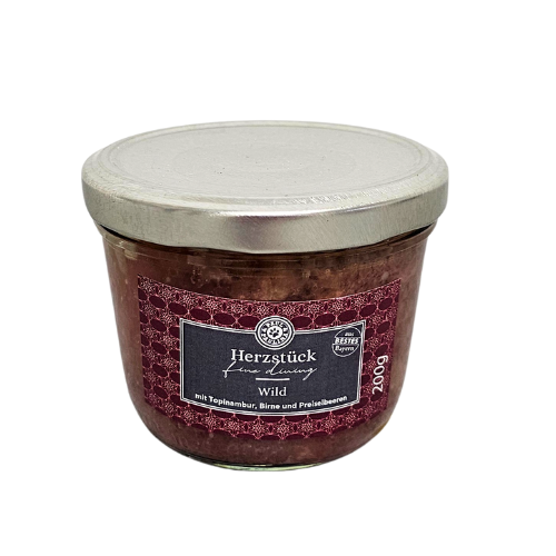 Szklany słoik z metalową pokrywką zawiera produkt spożywczy. Na etykiecie widnieje napis: \'Herzstück - mit Topinambur, Birne und Preiselbeeren\', a także oznaczenie \'200g\'.