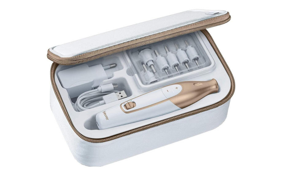 Zestaw do pielęgnacji paznokci w białym etui, zawierający frezarkę, ładowarkę USB oraz kilka wymiennych końcówek. Na frezarce widoczne jest logo \'beurer\'.