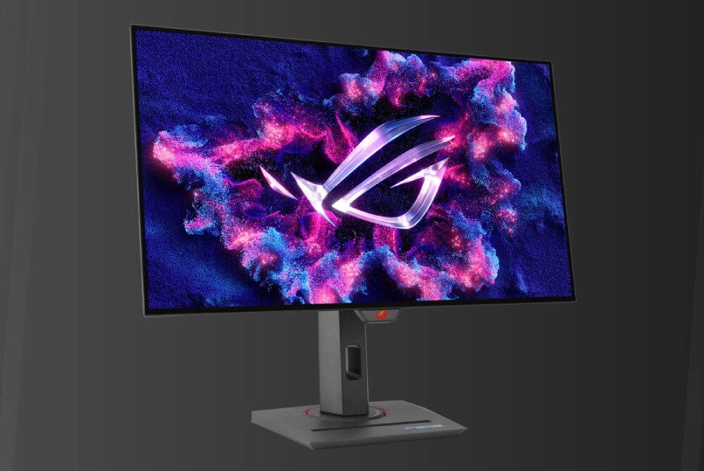 Monitor z wyświetlaczem pokazującym kolorową grafikę z logo ROG na tle abstrakcyjnych wzorów. Monitor ma nowoczesną podstawę z prostokątną kolumną.