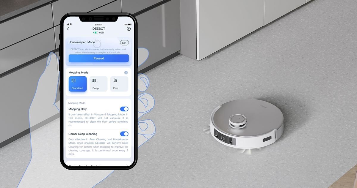 Na podłodze znajduje się biały robot sprzątający. Obok widoczny jest ekran smartfona z aplikacją DEEBOT, pokazującą różne tryby sprzątania.