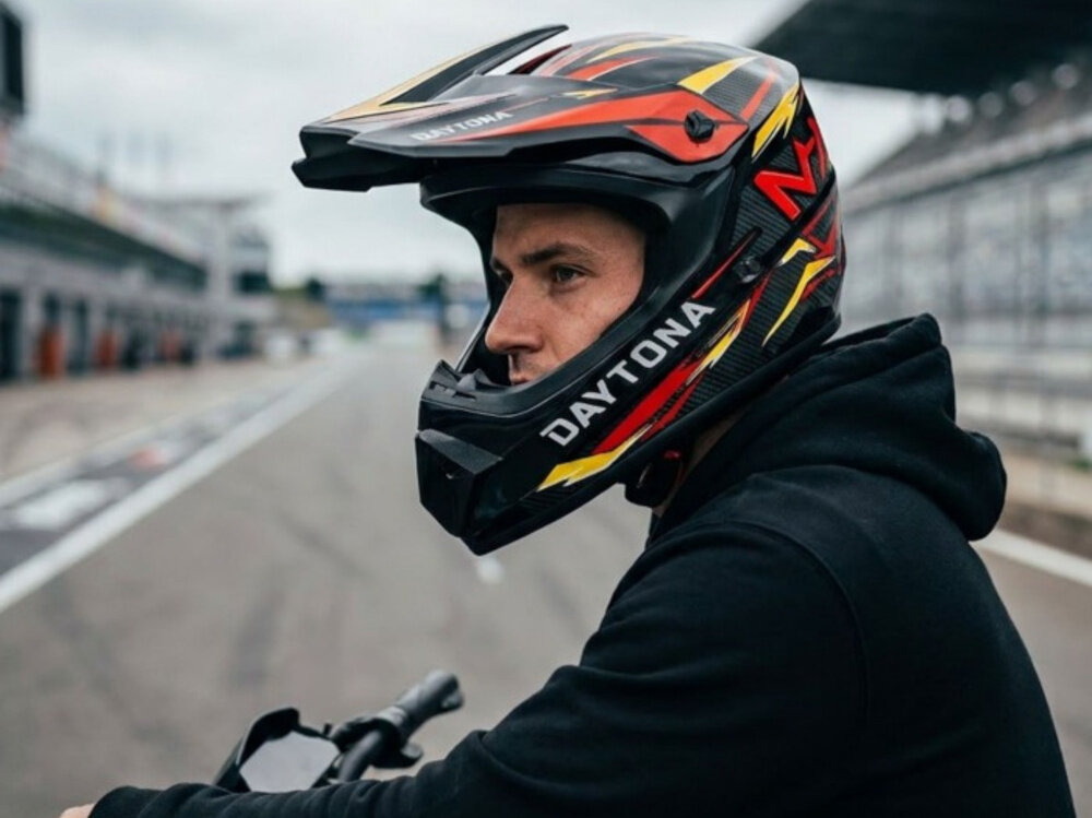 Kask MOTUS Daytona Full Face (rozmiar M) tor wyścigowy osoba w kasku patrzy w dal widok z boku wysoka ochrona zabudowana konstrukcja górna część głowy szczęka twarz większe poczucie pewności chroni przed podmuchami wiatru, kurzem i drobnymi zanieczyszczeniami