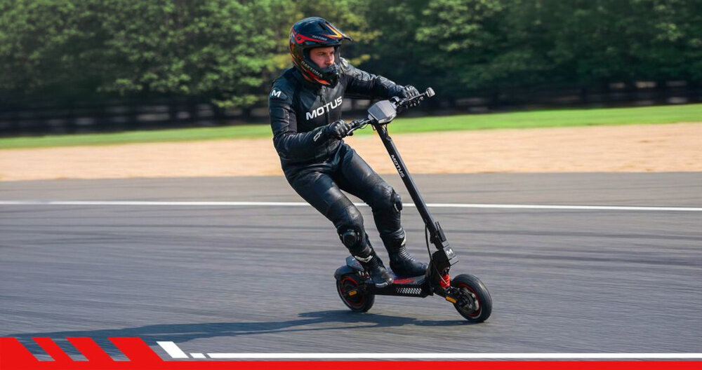 Kask MOTUS Daytona Full Face (rozmiar M) tor wyścigowy osoba w kasku i stroju sportowym jedzie na hulajnodze elektrycznej po torze szersza ochrona wytrzymała skorupa z ABS akrylonitryl-butadien-styren warstwa EPS expanded polystyrene, polistyren ekspandowany pochłania energię uderzenia ochrona w sytuacjach awaryjnych zmniejsza skutki upadków