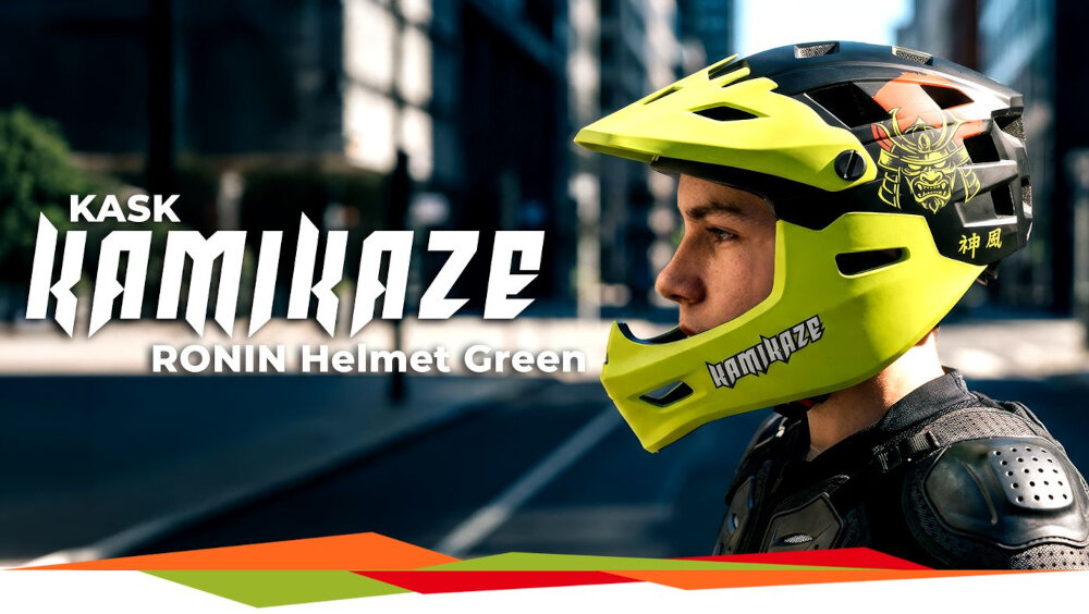 Osoba nosi zielony kask full face z napisem \'KAMIKAZE\' i grafiką samuraja. Obok widoczny jest tekst: \'KASK KAMIKAZE RONIN Helmet Green\'.