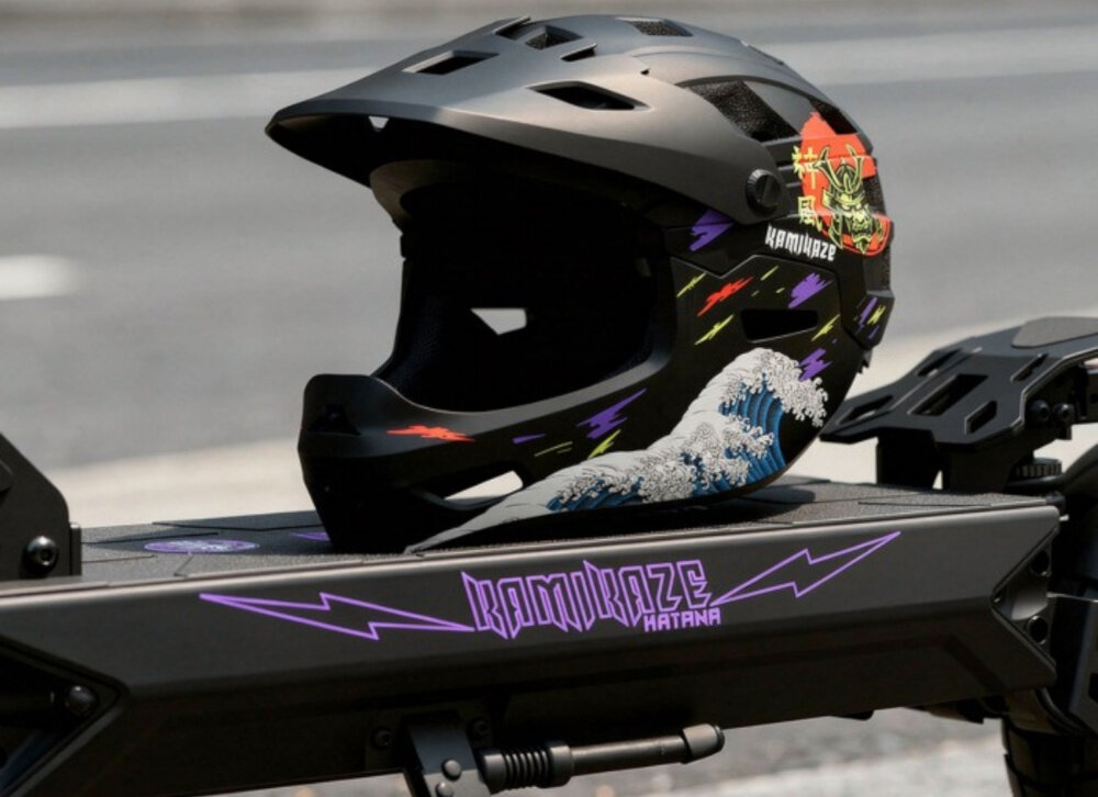 Czarny kask z kolorowymi grafikami i napisem \'KAMIKAZE\' leży na desce z napisem \'KAMIKAZE KATANA\'.