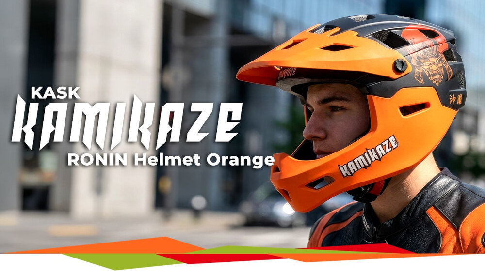 Osoba nosi pomarańczowy kask full face z napisem \'KAMIKAZE\' na ulicy. Obok widoczny jest tekst: \'KASK KAMIKAZE RONIN Helmet Orange\'.