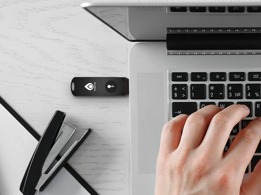 Klucz zabezpieczający Thetis podłączony do laptopa umożliwia bezpieczne logowanie podczas pracy biurowej przy stanowisku komputerowym  