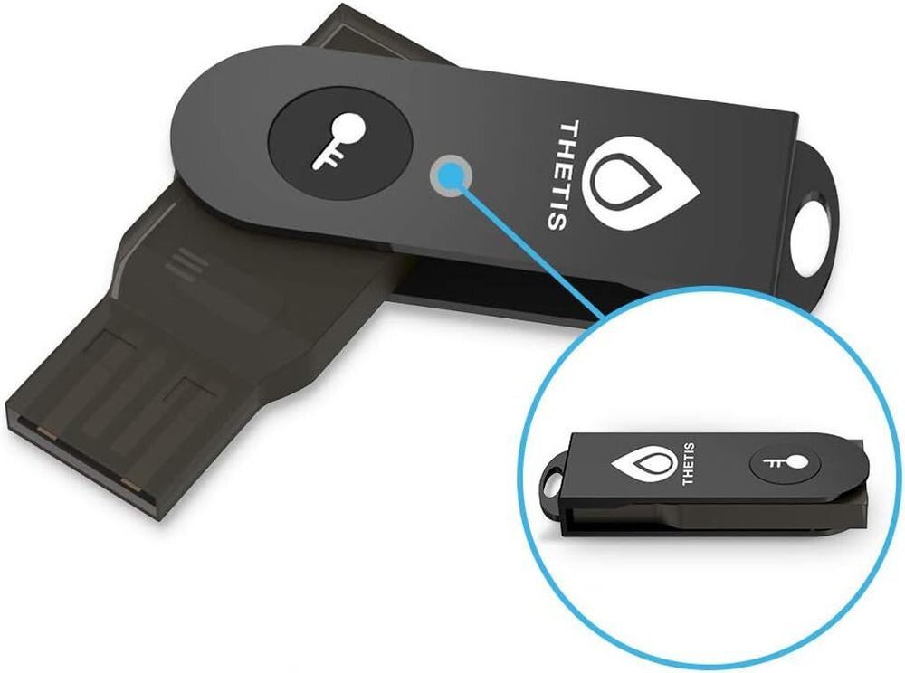 Klucz zabezpieczający Thetis z przyciskiem uwierzytelniania i złączem USB prezentowany jest na jasnym tle produktowym 