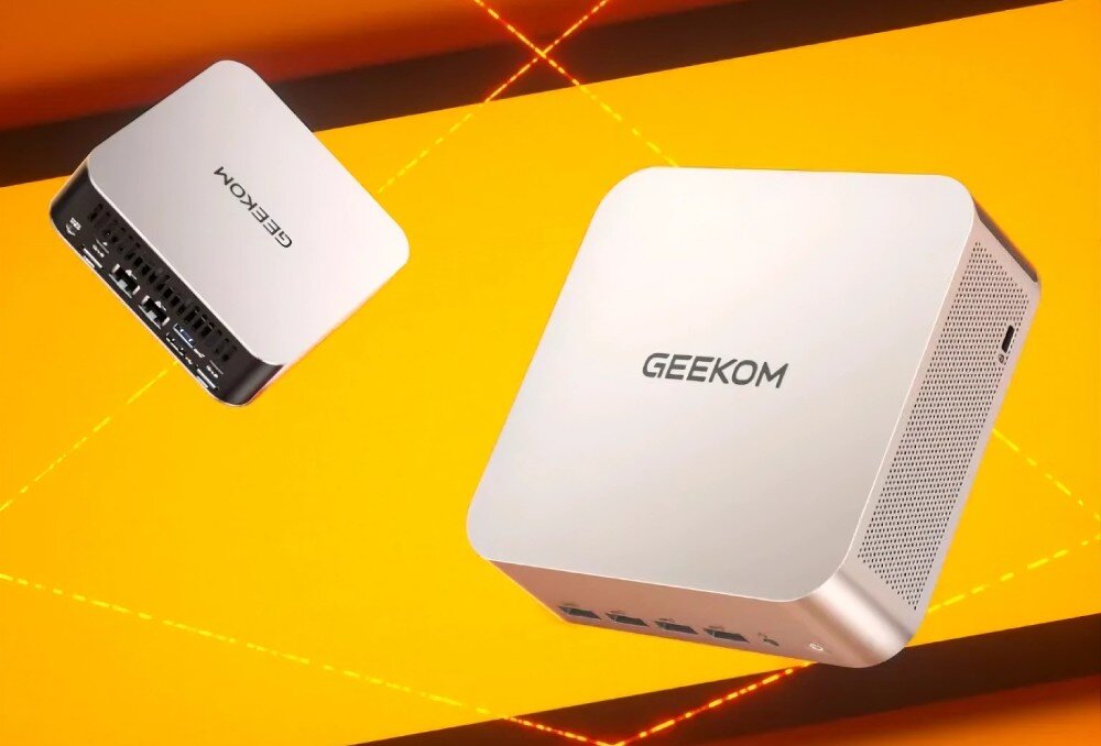 Komputer GEEKOM A7 Max Dwa minikomputery ukazane na tle z jasną linią, jeden widoczny od przodu, drugi od tylnego panelu z portami