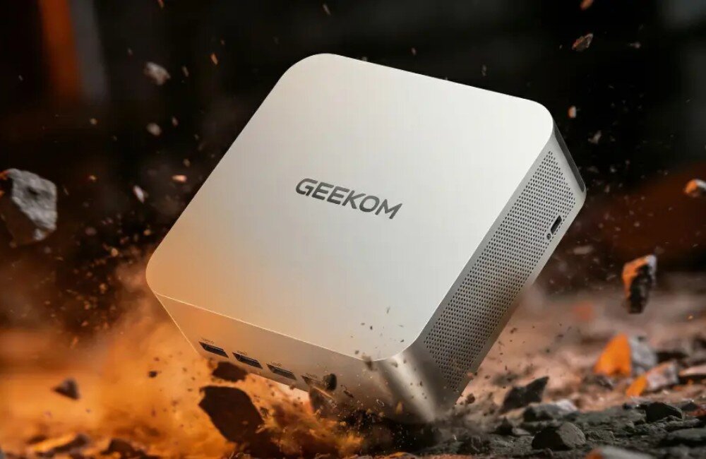 Komputer GEEKOM A7 Max Minikomputer unoszący się nad dynamicznie rozpadającym się podłożem z odłamkami