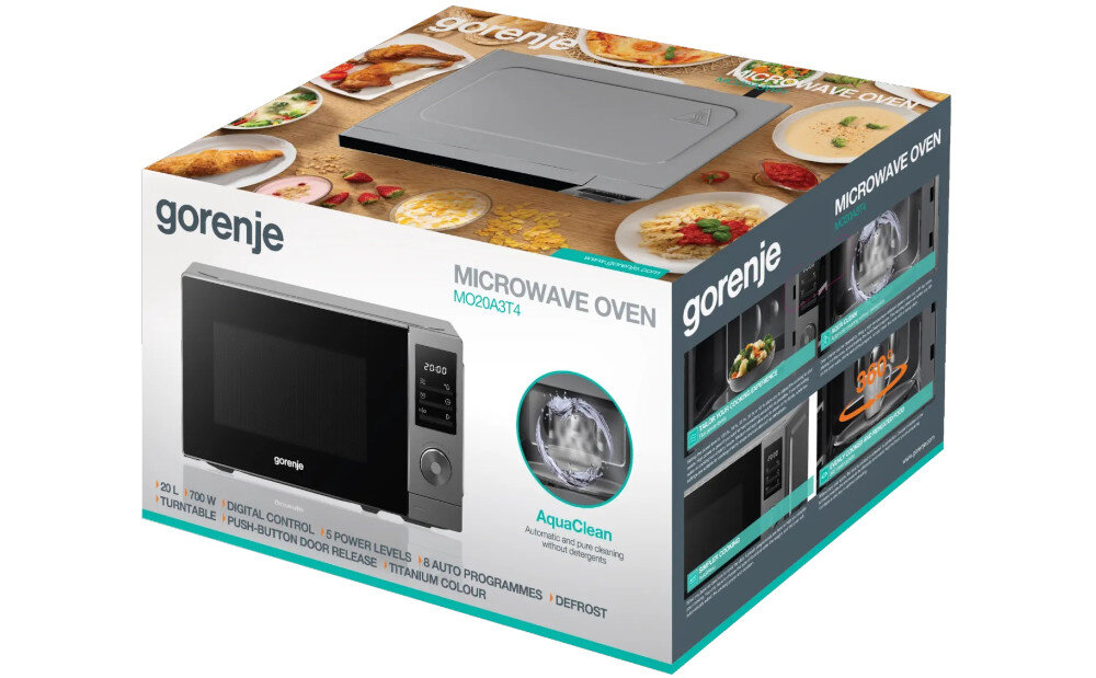 KUCHENKA MIKROFALOWA GORENJE MO20A3T4 Opakowanie kuchenki mikrofalowej Gorenje z dużym zdjęciem urządzenia oraz potrawami rozmieszczonymi wokół na drewnianym tle. Na pudełku widoczne są napisy „MICROWAVE OVEN MO20A3T4”, „AquaClean” oraz informacje o funkcjach, m.in. 20 l pojemności, 700 W mocy, 5 poziomach mocy i 8 programach automatycznych