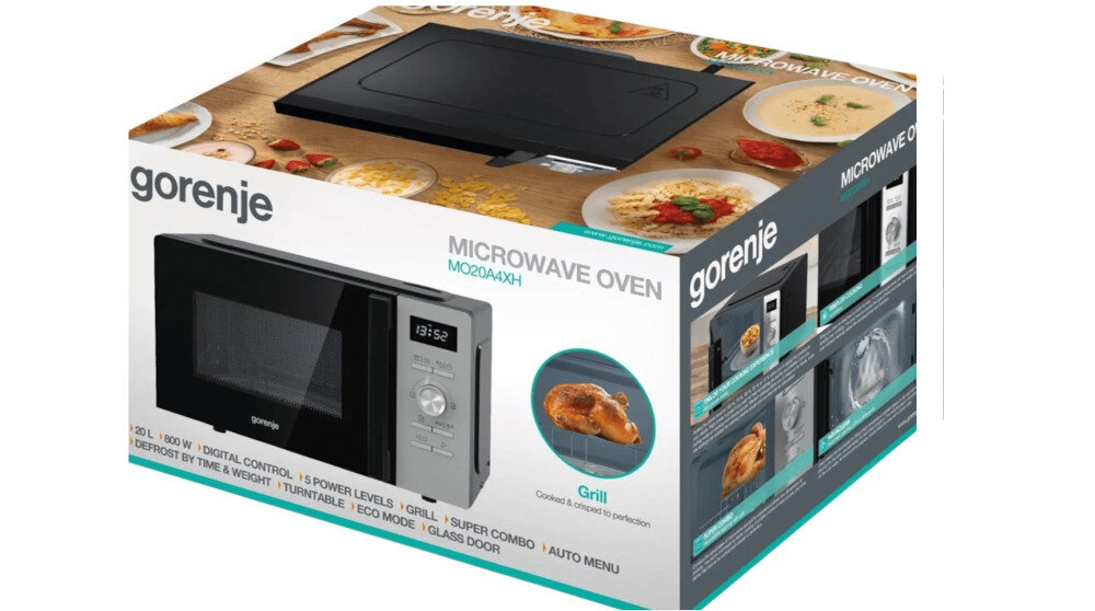 KUCHENKA MIKROFALOWA GORENJE MO20A4XH Opakowanie kuchenki mikrofalowej Gorenje z dużym zdjęciem urządzenia oraz potrawami rozmieszczonymi wokół na drewnianym tle. Na pudełku widoczne są napisy „MICROWAVE OVEN MO20A3T4”, „AquaClean” oraz informacje o funkcjach, m.in. 20 l pojemności, 700 W mocy, 5 poziomach mocy i 8 programach automatycznych