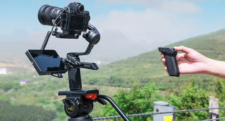 Gimbal FEIYUTECH Scorp 3 Kit Czarny na tle krajobrazu.
