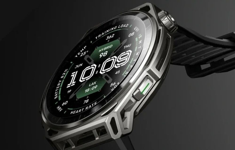 Smartwatch z okrągłym wyświetlaczem pokazuje godzinę 10:09 oraz różne dane, takie jak \'TRAINING LOAD\', \'BATTERY 52%\', \'HEART RATE\'. Obudowa zegarka wykonana jest ze stali nierdzewnej z widocznymi przyciskami i paskiem.
