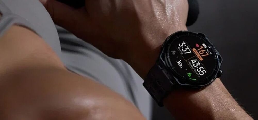 Osoba nosi smartwatch z czarnym paskiem, na którego wyświetlaczu widoczne są dane dotyczące tętna (167) oraz czas 3:37 i 43:55.