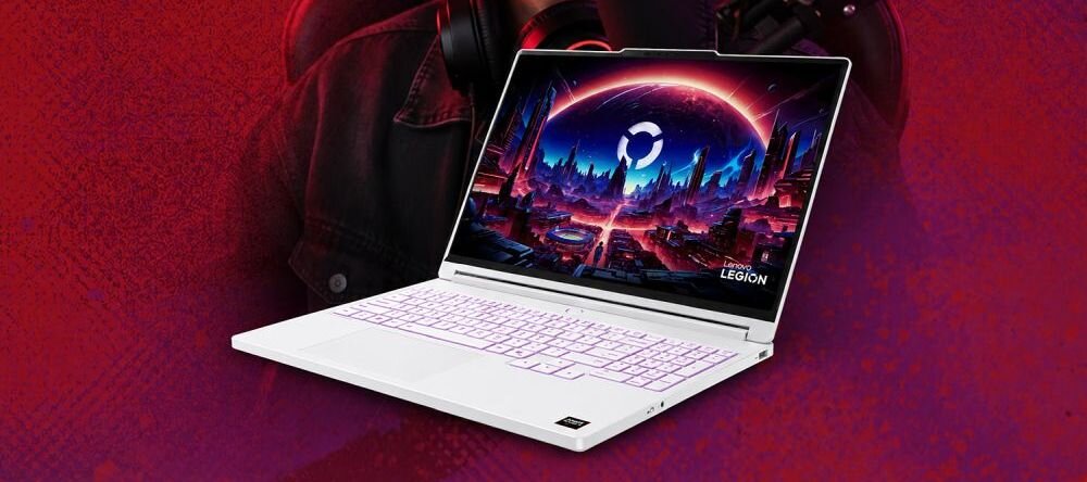 Biały laptop z podświetlaną klawiaturą wyświetla kolorową grafikę futurystycznego miasta na ekranie. Na obudowie widoczne jest logo \'Legion\'.