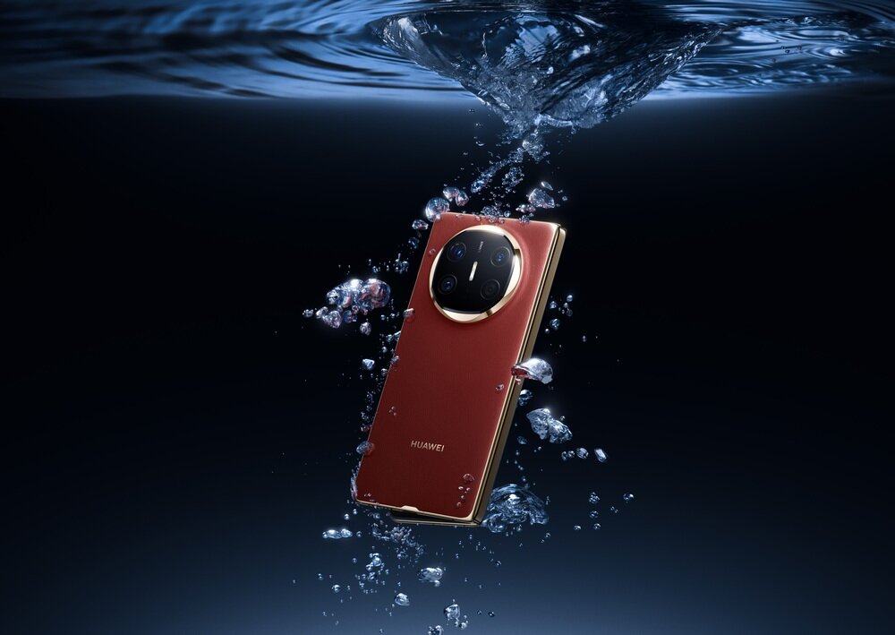 Czerwony smartfon zanurzony w wodzie, otoczony bąbelkami. Na obudowie widoczne jest logo \'HUAWEI\'.