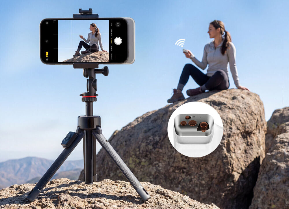 Na zdjęciu widać statyw z zamocowanym smartfonem, który fotografuje osobę siedzącą na skale. W prawym dolnym rogu znajduje się zbliżenie na elementy uchwytu selfie.