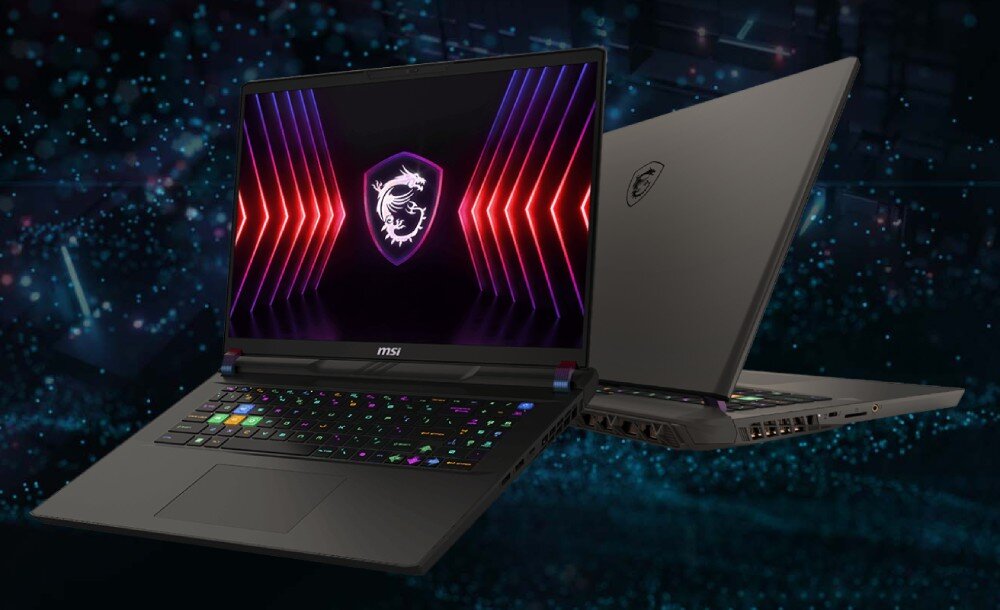 Dwa laptopy z logo smoka na ekranie i obudowie, z podświetlaną klawiaturą w różnych kolorach. W tle widoczny jest rozmyty, ciemny wzór z niebieskimi i czerwonymi elementami.