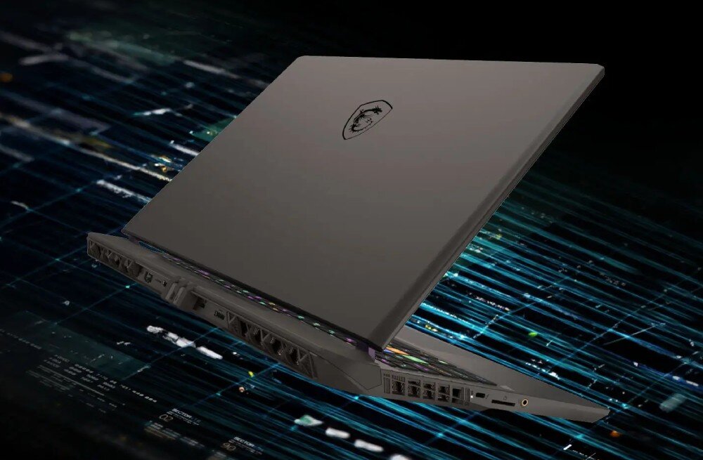 Laptop z logo producenta na pokrywie, ustawiony pod kątem, z widocznymi portami i otworami wentylacyjnymi. Tło przedstawia abstrakcyjne, cyfrowe wzory.